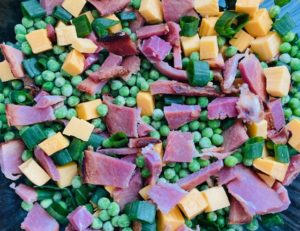 Ham and pea salad ingredients tossed together