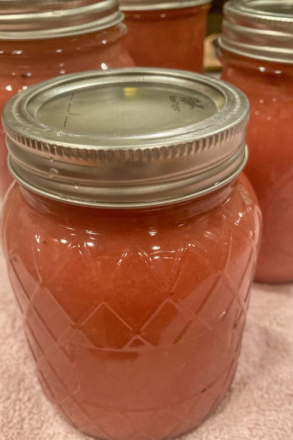 canned applesauce in jars with pink pearl apples
