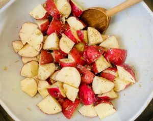 Roasted red skin potatoes with rosemary in mixing bowl
