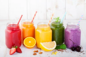 Best ways to use an immersion blender in Smoothies, juices, beverages, drinks variety with fresh fruits and berries on a white wooden background