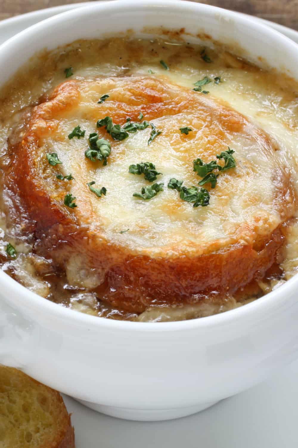 easy slow cooker french onion soup with sausage finished under the broiler with melted cheese and bread