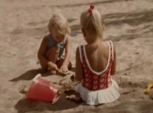 best gifts for beach lovers: vintage beach photo of two young girls playing in the sand