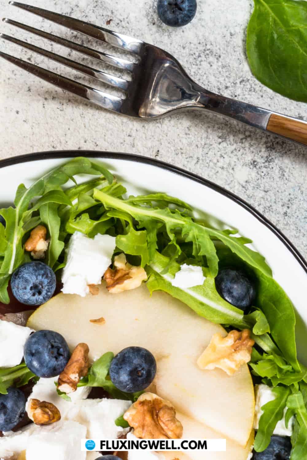easy walnut pear salad with blueberries and feta cheese on a plate