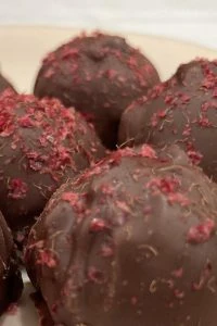 dark chocolate raspberry truffles closeup with raspberry dust