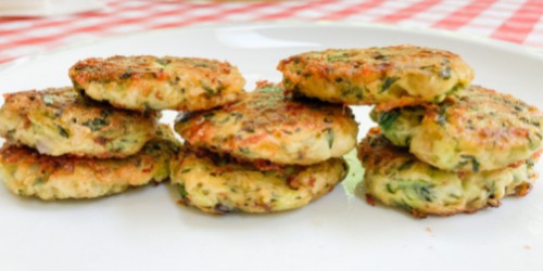 zucchini fritters with cheese stacked in a row
