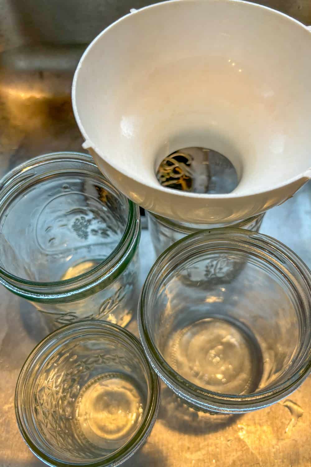 filling blueberry orange jam jars with funnel