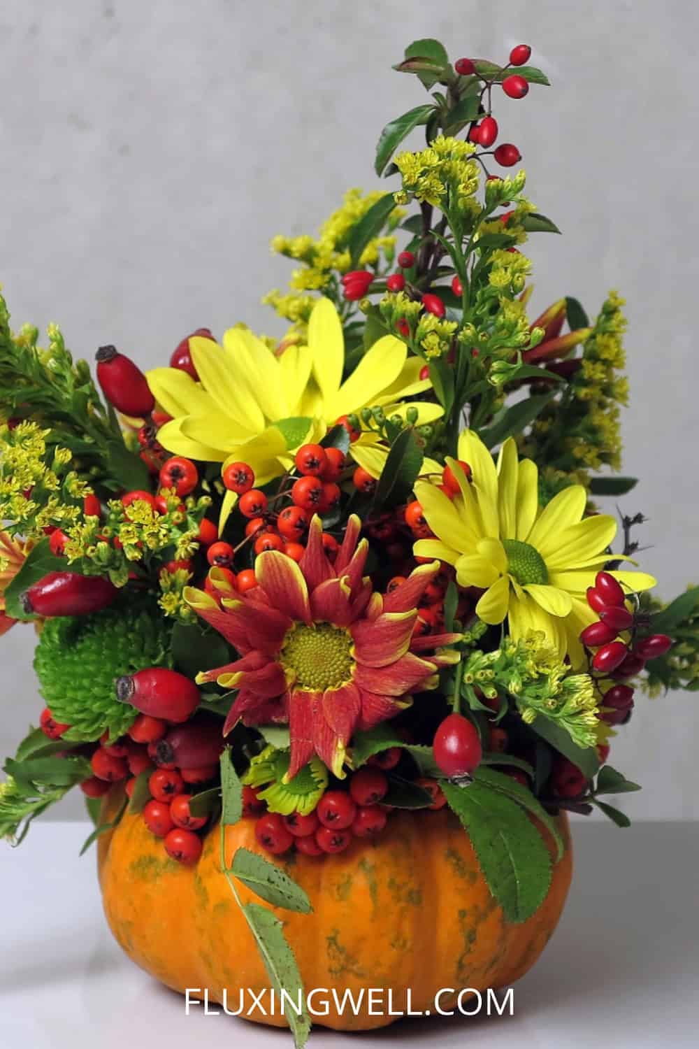 pumpkin centerpieces with flowers chrysanthemums and greenery